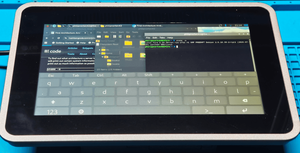 The fully assembled and working Argon Industria HMI 7C. Showing a web browser a file manager and a terminal running. The bottom third of the screen is taken up by an on screen keyboard.