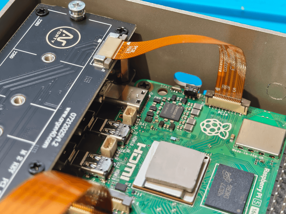 A close up the ribbon cable connecting the NVMe sister board to the Raspberry Pi.