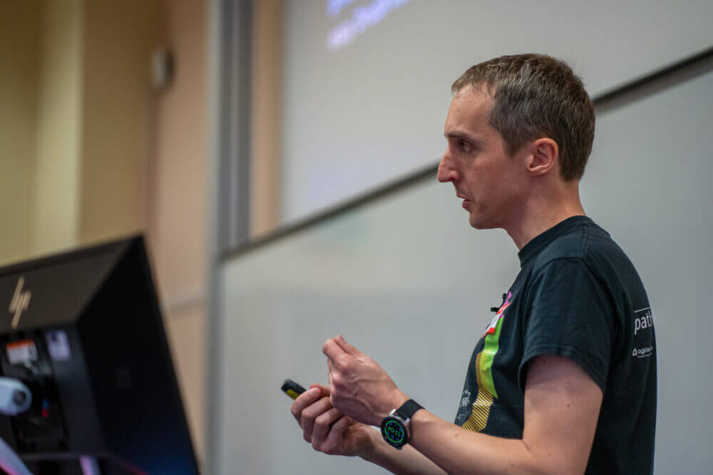 Phil Norton doing a talk at DrupalCamp Scotland 2025. He is facing towards the right of the image, looking at the off audience who are out of the image.