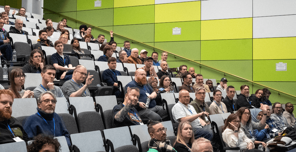 A picture of the audience for DrupalCamp England 2026, sat down in the main room.