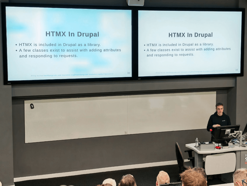 Phil Norton, talking at DrupalCamp England 2026 with his talk HTMX in Drupal. The image shows two protector screens with the same information.