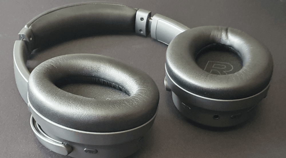 Kiwi Ears Ardor headphones sitting on a desk. Showing the ear cups pointing up and the R for the right side clearly visible in the cup.