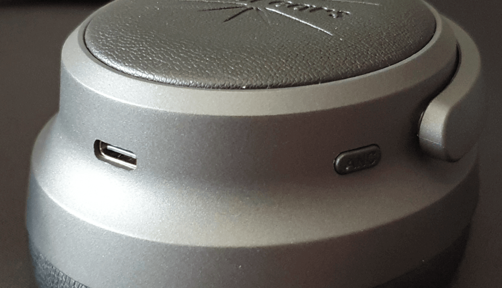 A close up of the left hand side of the Kiwi Ears Ardor, showing the USB-C connection and the active noise cancelling button.