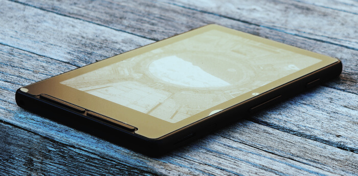The Xteink X4, lying on a wooden table.